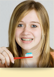 stock photo of a teen girl with braces brushing her teeth